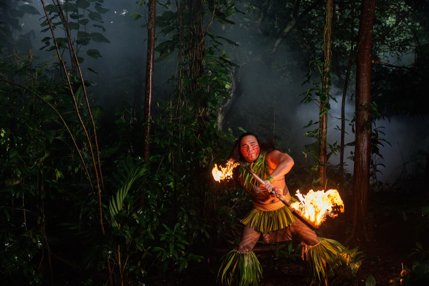 Fire knife dancer performing in the forest