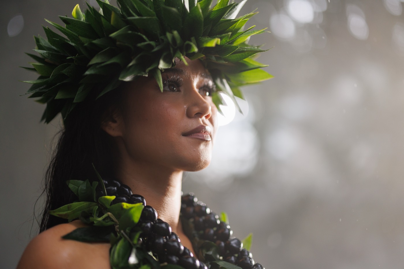 Performer wearing a lei poʻo in the mist